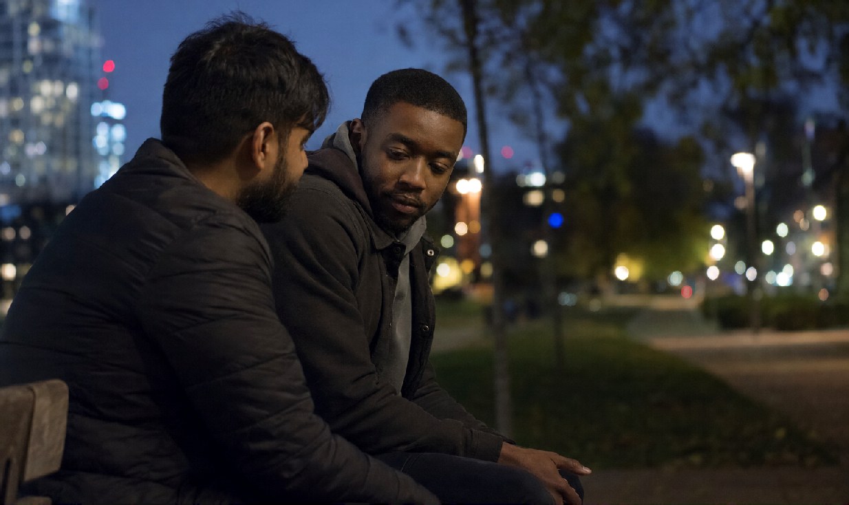Two mates talking on a bench in the evening
